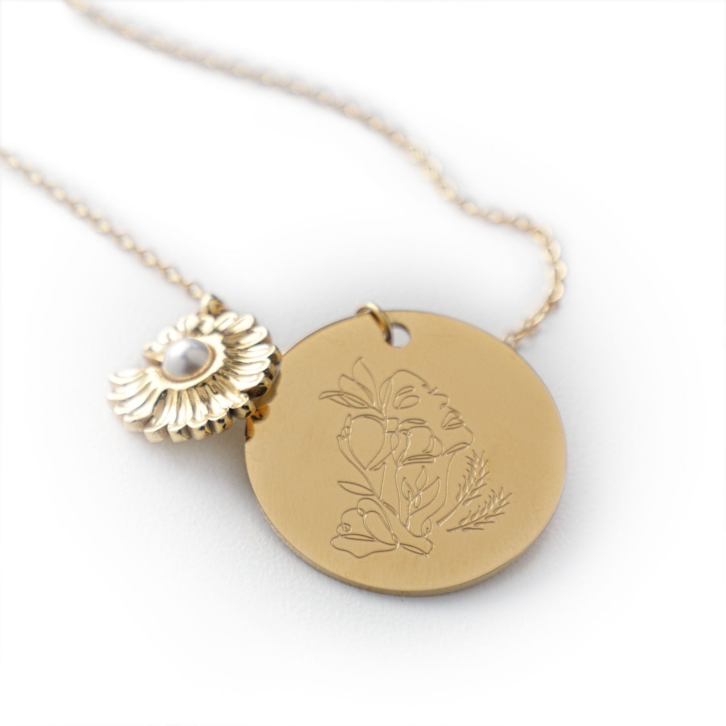 Gold necklace with two pendants on a white background