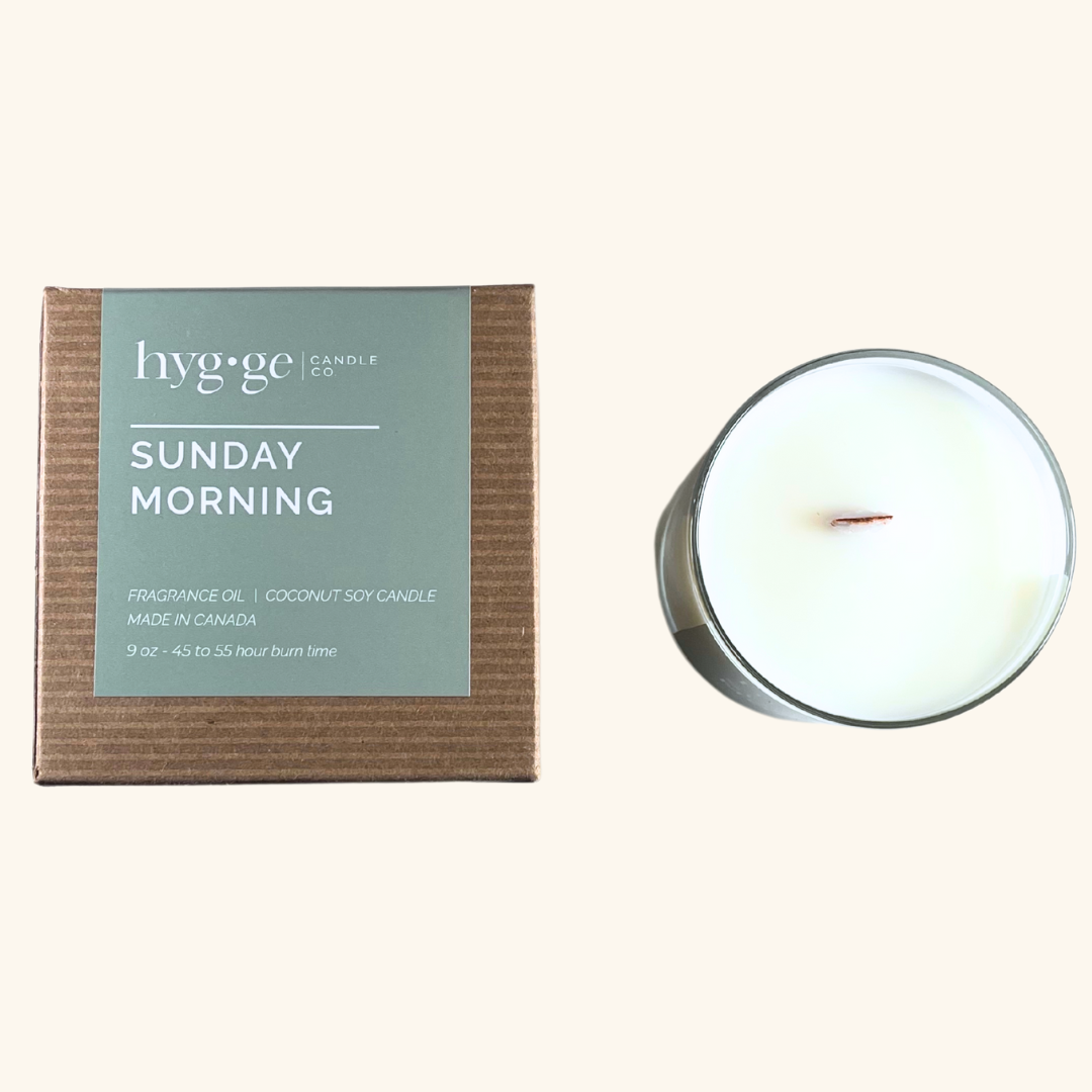 9 oz “Sunday Morning” coconut soy candle by Hygge Candle Co. in green-labeled kraft box, featuring a wooden wick and clean-burning wax.