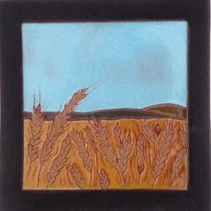 Artistic depiction of a field with barley under a blue sky, framed in black.