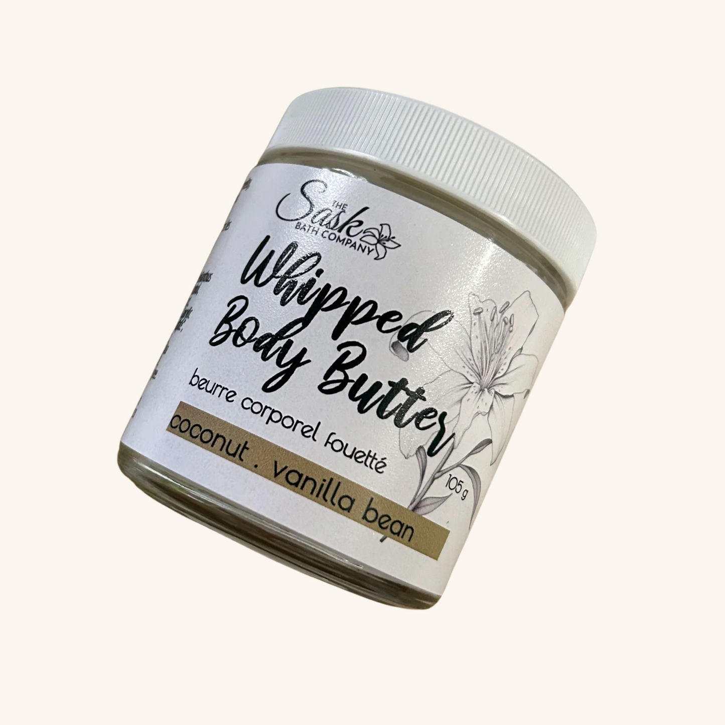 The Sask Bath Co. Whipped Body Butter in Coconut Vanilla Bean scent, shown in a 105g glass jar with floral label design.
