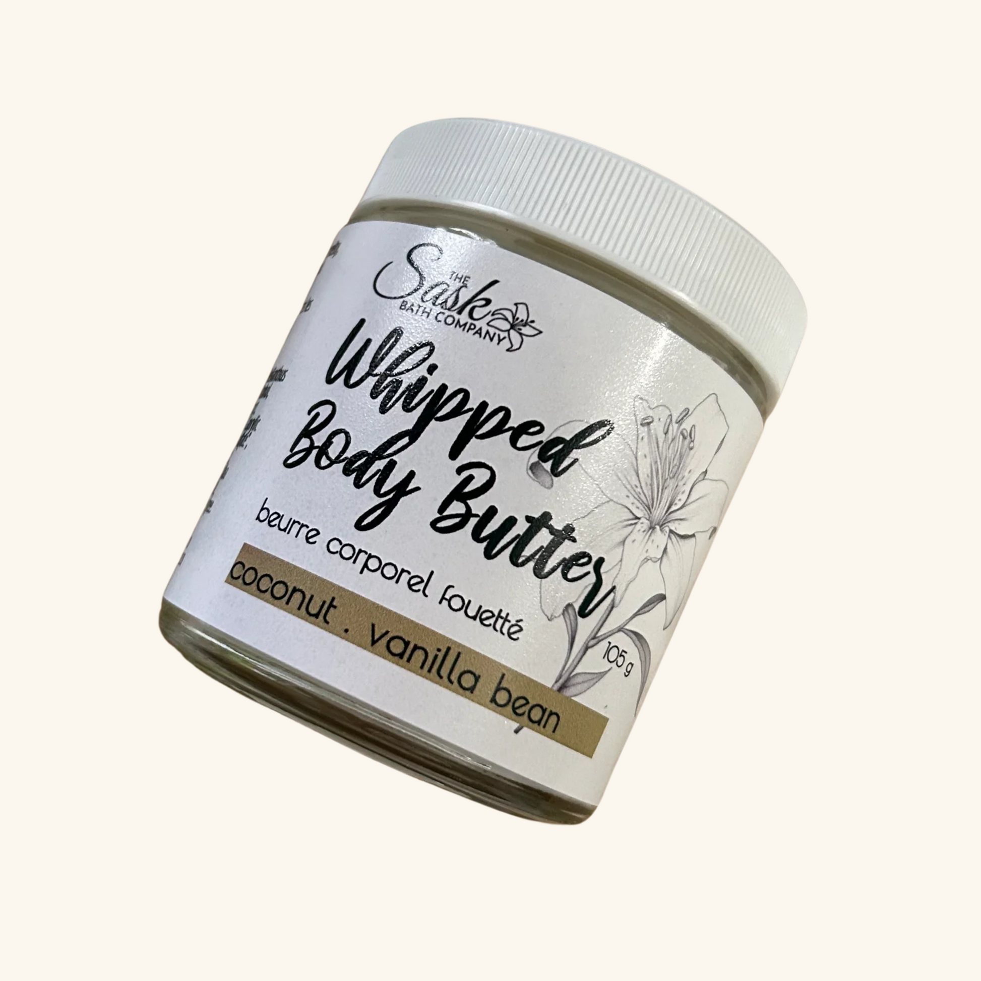 The Sask Bath Co. Whipped Body Butter in Coconut Vanilla Bean scent, shown in a 105g glass jar with floral label design.