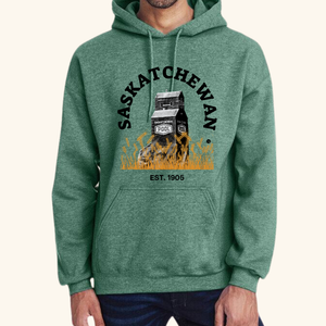 Honor the legacy of the prairies with our Prairie Grain Elevator Hoodie, T-shirt, or Sweatshirt featuring a striking decal of a classic grain elevator standing tall in a golden wheat field. Grain elevators are a proud symbol of the Prairies, though fewer remain every year, making this design a tribute to the region’s rich agricultural heritage.

Premium Quality Gildan Apparel: Made from soft, durable fabric, our Gildan standard-sized garments come in sizes S to XXL for a comfortable fit.
