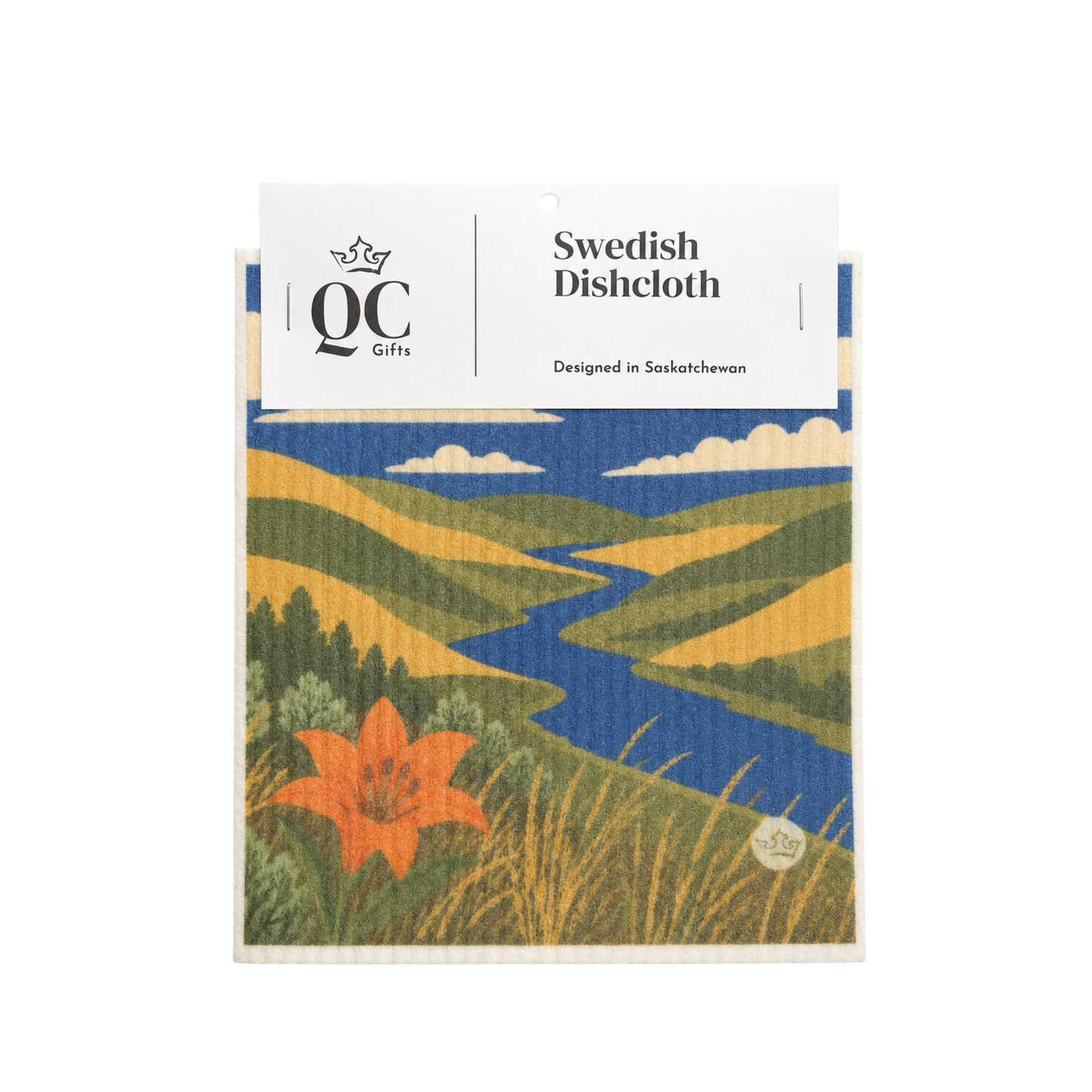 A packaged Swedish dishcloth with a colorful landscape print featuring a winding blue river, green and yellow hills, clouds, and an orange flower. The white header card reads 'QC Gifts' and 'Swedish Dishcloth'.