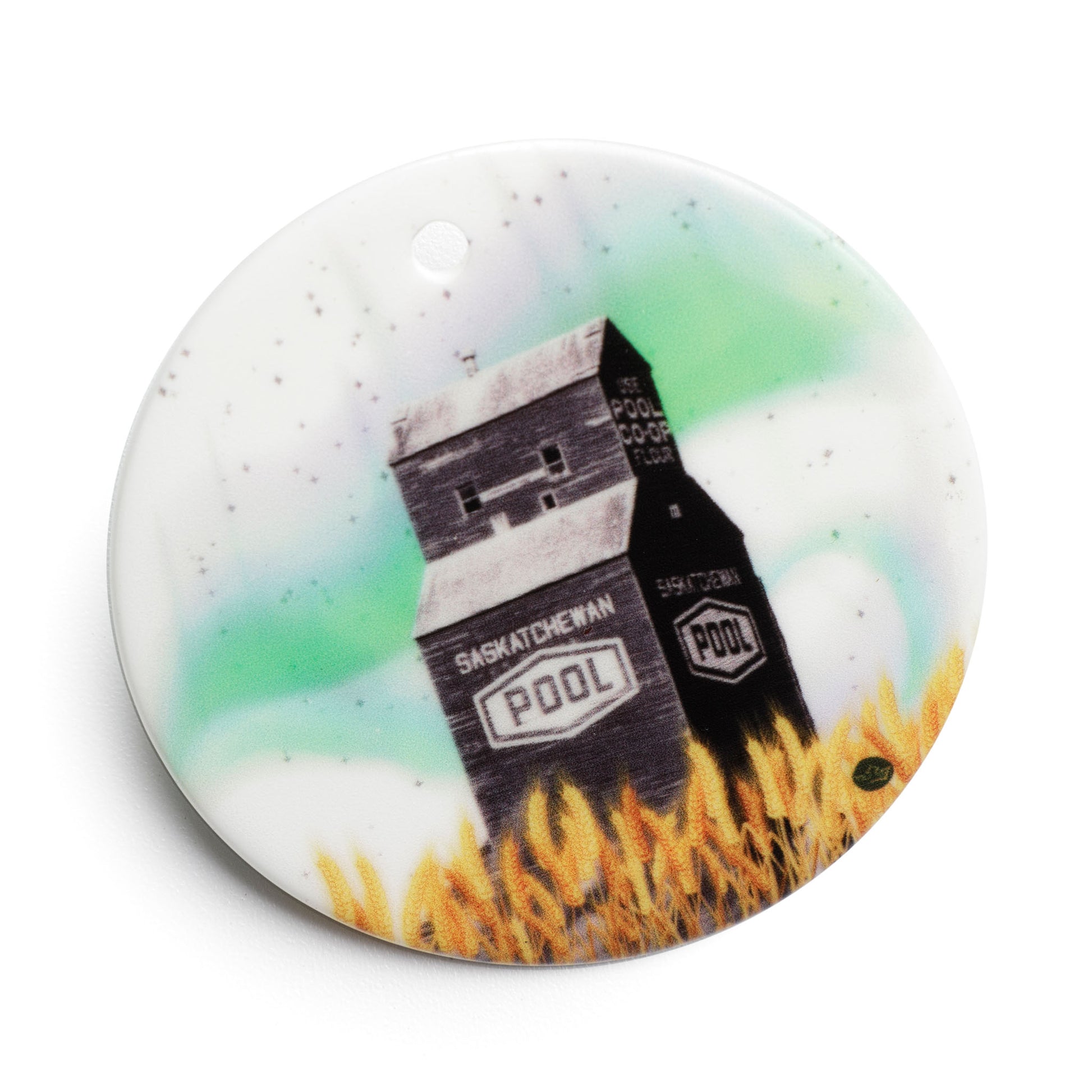 Round ceramic ornament with Saskatchewan Pool logo and grain elevator design on a white background
