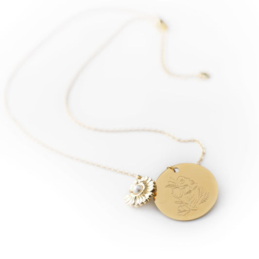 Gold necklace with two pendants on a white background