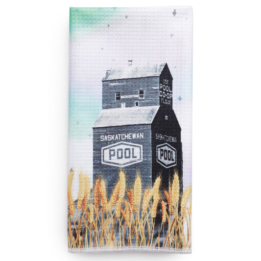 Tea towel with a design of a grain elevator and wheat field, featuring the 'Saskatchewan Pool' branding.