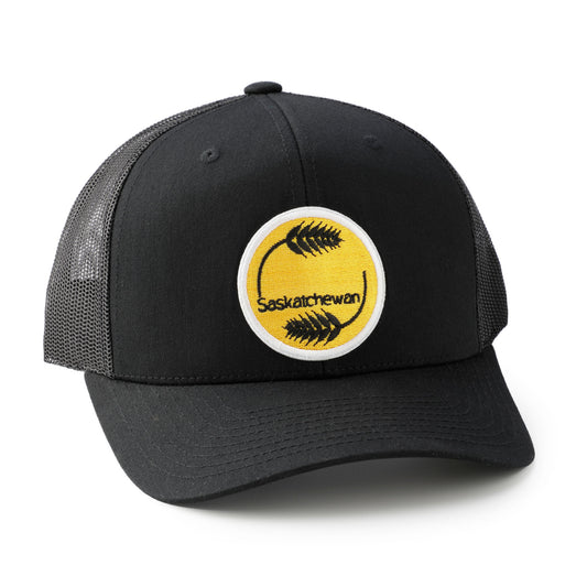 Black trucker cap with yellow and white emblem featuring 'Saskatchewan' on a white background