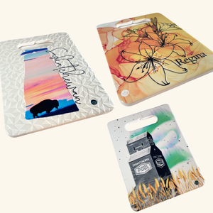 Collection of Prairie-inspired ceramic trivets, handcrafted in Turkey, featuring a bison sunset, Regina Prairie Lily, and Saskatchewan grain elevator design