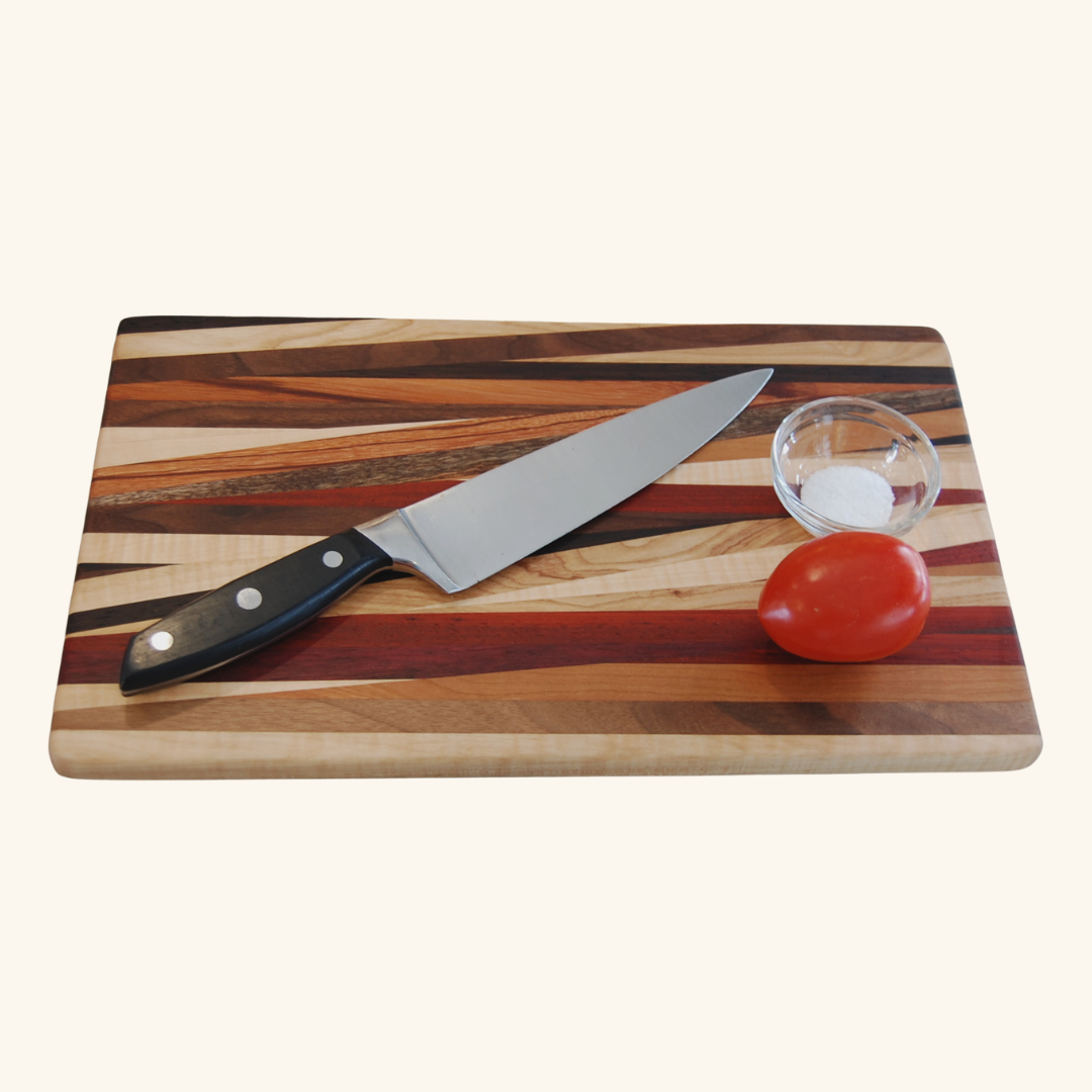 Handmade wooden cutting board by Rod Nernberg, crafted from multiple wood types, featuring a unique grain pattern and durable design for kitchen use.