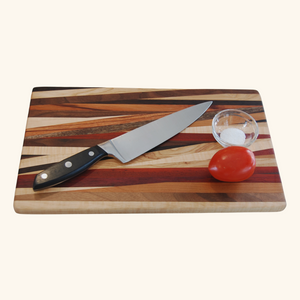 Handmade wooden cutting board by Rod Nernberg, crafted from multiple wood types, featuring a unique grain pattern and durable design for kitchen use.