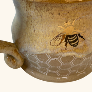 Side view of the handmade ceramic honey pot mug, highlighting the smooth glazed finish, sturdy handle, and intricate detailing