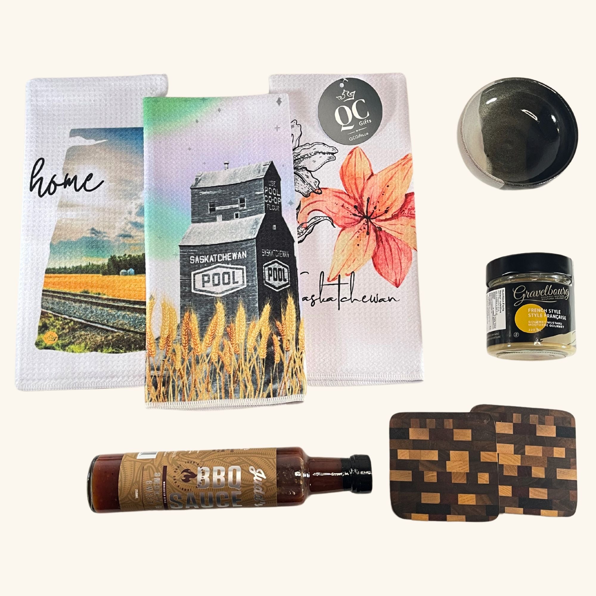 The Host Box – A curated gift set featuring handcrafted Prairie-inspired kitchen essentials, including Freba Pottery, gourmet mustard, BBQ sauce, and wooden coasters.