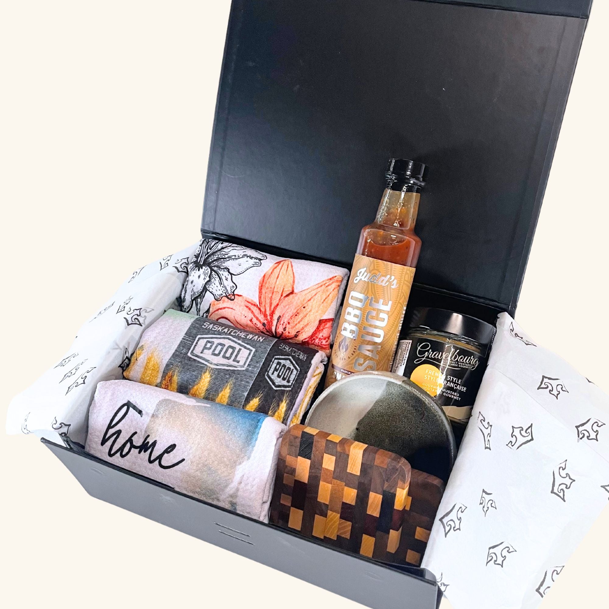 The Host Box – A curated gift set featuring handcrafted Prairie-inspired kitchen essentials, including Freba Pottery, gourmet mustard, BBQ sauce, and wooden coasters.