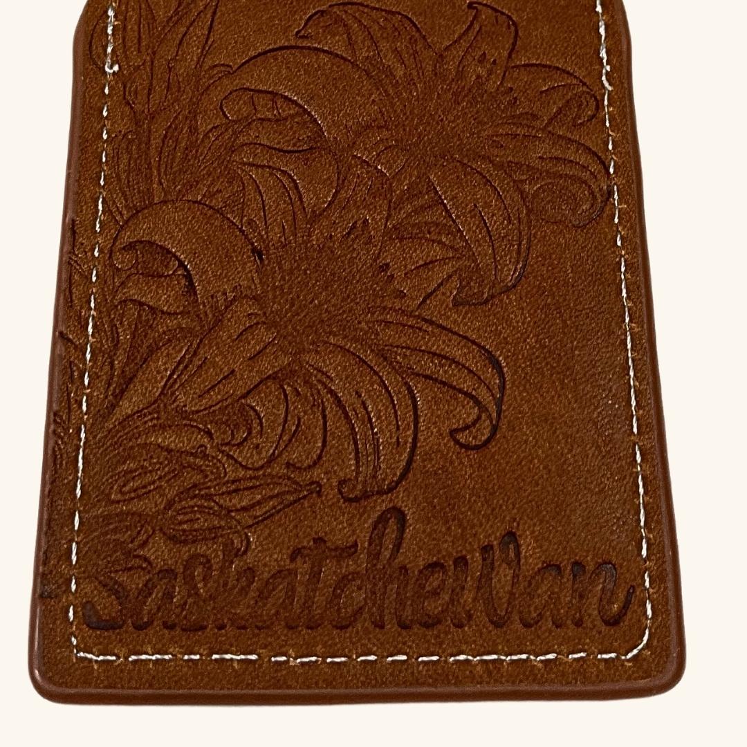 Leather luggage tag featuring an embossed Prairie Lily design, symbolizing Saskatchewan’s floral emblem.