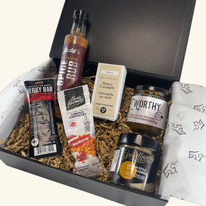 Prairie Tastes Gift Box – A curated collection of Saskatchewan-made gourmet snacks, including beef jerky, mustard, BBQ seasoning, caramel treats, and more.