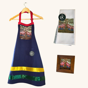 Flat-lay display of all items from the Singing to the Aspen collection, including the apron, framed print, tea towel, magnet, and ceramic mug.