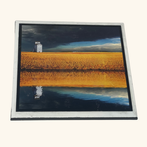 6x6 tile artwork capturing the reflection of a field and grain elevator, highlighting the serene beauty of Saskatchewan’s rural landscape.