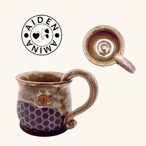 Close-up of the honeycomb texture and shimmering metallic bee design on Aiden Amina’s handcrafted ceramic honey pot mug.